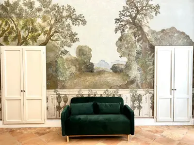 a living room with a green couch in front of a painting at Historic Fresco Suite Rome Colosseum Boutique Stay in Rome