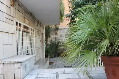 a courtyard with a bench and plants next to a building at casa vacanze Borgo San Lazzaro in Rome