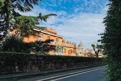 a street with a building and a dome in the background at San Pietro in Vaticano Terrazza Giovy in Rome