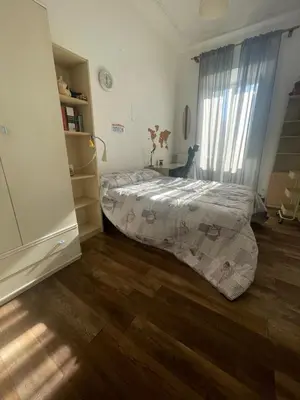 a bedroom with a bed and a wooden floor at Sunny apartment in central Rome in Rome