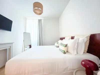 a white bedroom with a large white bed with pillows at Vatican Apartment Borgo Pio 160 by MSuite in Rome