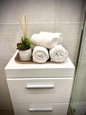 a stack of towels on a shelf in a bathroom at Appartamento metro Ponte Lungo in Rome
