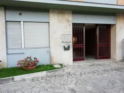 a building with two red doors and a pot of flowers at Bright and Cozy Studio Apartment near Trastevere Station in Rome