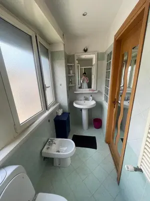 a bathroom with a sink and a toilet and a mirror at Bright and Cozy Studio Apartment near Trastevere Station in Rome