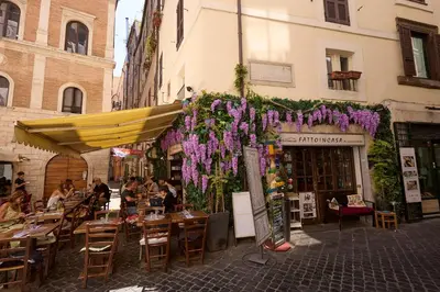 a restaurant with purple flowers hanging from a building at Navona Maison in Rome