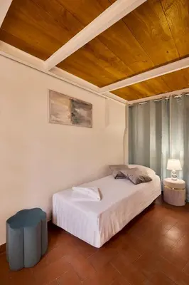 a bedroom with a white bed and a wooden ceiling at Navona Maison in Rome