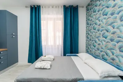 a living room with a blue couch and a table at Stylish Vatican Stay - WiFi Metro Walk Everywhere in Rome