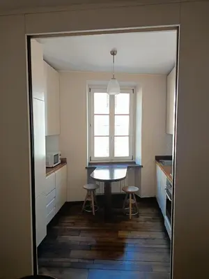a kitchen with a table and two stools and a window at Via del Corso Apartment in Rome