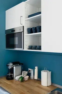 a kitchen with white cabinets and a wooden counter top at Cornelia Vatican Suites in Rome