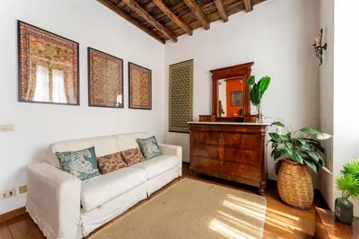 a living room with a white couch and a wooden dresser at Domus Leopardo, Typical Trastevere Flat in Center in Rome