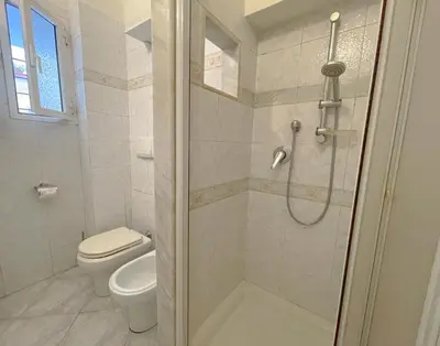 a white bathroom with a toilet and a shower at MARIA TERESA Apartment II - Refined Living with Excellent City Links - Via Alessandria - QUARTIERE TRIESTE in Rome