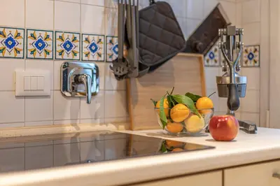 a kitchen counter with a bowl of fruit on a sink at Key Apartment Trastevere in Rome