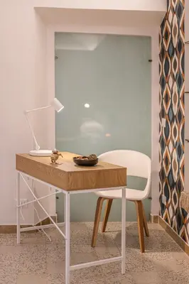 a desk with a white chair and a table with a lamp at Key Apartment Trastevere in Rome
