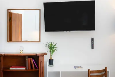 a flat screen tv hanging on a wall next to a desk at Cola di Rienzo Apartment by Rental in Rome in Rome