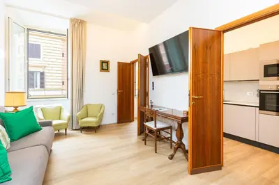 a living room with a couch and a table and a kitchen at Cola di Rienzo Apartment by Rental in Rome in Rome