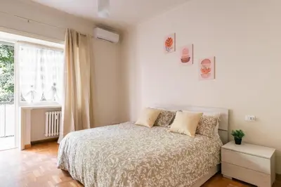a white bedroom with a bed and a window at MaSa Holidays House Vatican in Rome