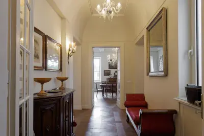 a hallway with a red couch and a chandelier at Sant'Angelo Apartment in Rome