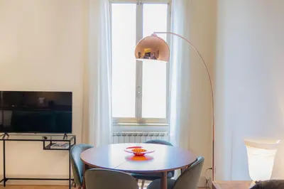 a dining room with a table and a lamp at Casa Prati by Rental in Rome in Rome