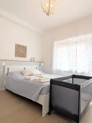 a bedroom with a bed and a chandelier at Armonia Mediterranea Apartments in Rome