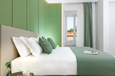 a bedroom with a white bed with green walls at St Peter Museum in Rome