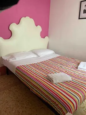 a bed with a white headboard in a bedroom at Three bedroom apartment with a view in Monti in Rome