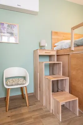 a bedroom with a bunk bed with a chair and a desk at Vatican Cozy Studio in Rome