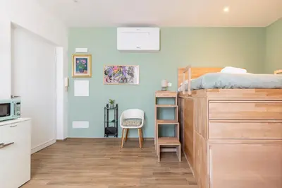 a bedroom with a bunk bed and a kitchen at Vatican Cozy Studio in Rome