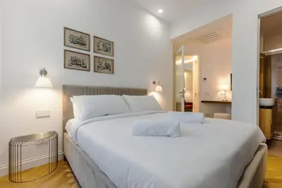 a large white bed with two pillows on top of it at Chigi Home in Rome