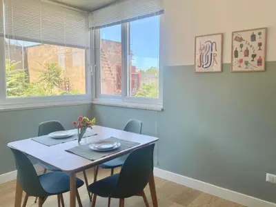 a dining room with a table and chairs and two windows at Borgo Capua in Rome