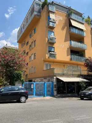 a building with cars parked in front of it at Nina House Roma in Rome