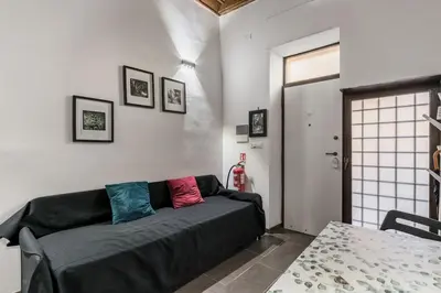 a small kitchen with white cabinets and a table at Valentina's studio in Rome