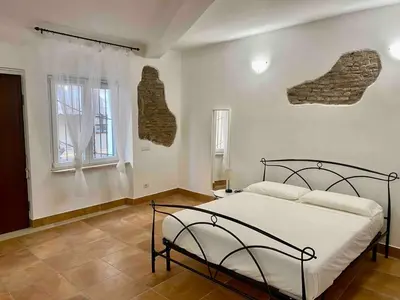 a bedroom with a bed and a stone wall at Casa Bonosa in the Heart of Rome CISE 25369 in Rome