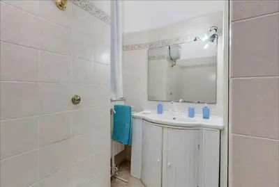 a white bathroom with a sink and a mirror at Holiday Jeans Apartment in Rome
