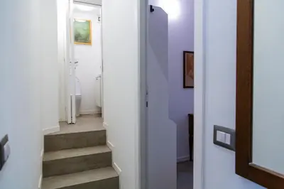 a hallway with stairs in a home with purple walls at Habemus Casam in Rome