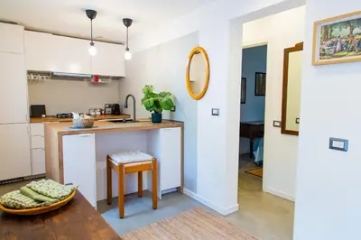 a kitchen with a counter and a table with a stool at Habemus Casam in Rome