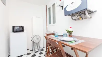 a small kitchen with a table and a refrigerator at Ostilia Loft in Rome