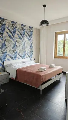 a bedroom with a large bed with a blue and white wallpaper at LIFEI House in Rome