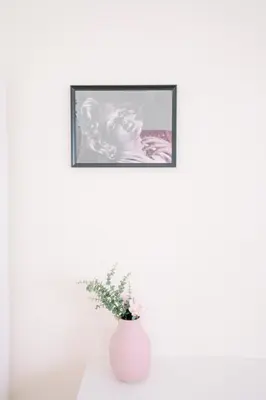 a white vase sitting on a table with a picture at Marilyn Rooms in Rome