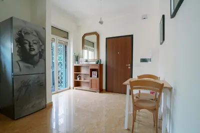 a living room with a table and a refrigerator at Marilyn Rooms in Rome