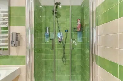 a bathroom with a shower with green tiles at VaticanRhome I in Rome