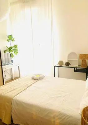 a bedroom with a white bed with a large window at ZAIRA ROMA HOUSE, alloggio per uso turistico in Rome