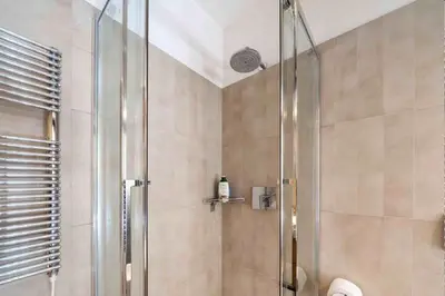 a shower with a glass door in a bathroom at Charming in Rome