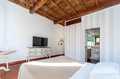 a bedroom with a bed and a tv and a table at Romantic in Rome