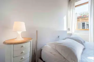 a bedroom with a bed and a lamp on a dresser at Romantic in Rome