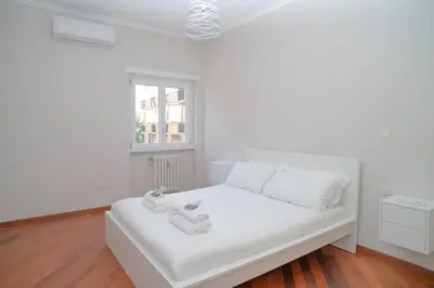 a white bed in a room with a window at Stile e spazio nel cuore di Roma in Rome