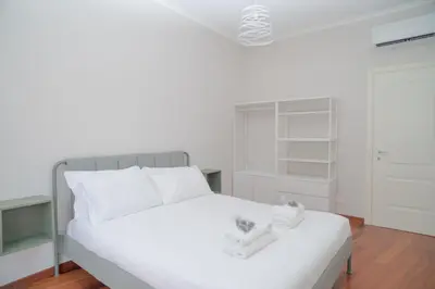 a white bedroom with a white bed with white pillows at Stile e spazio nel cuore di Roma in Rome