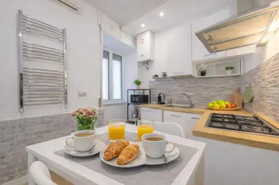 a kitchen with a table with two cups of coffee and croissants at Open Space Moderno a 20 Minuti dal Colosseo vicino alla Metro A e C in Rome