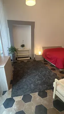a bedroom with a red bed and a rug at Colosseo Promenade in Rome