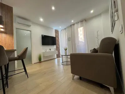 a living room with a couch and a television on the wall at Gianvenuti House Rome - Metro A with Jacuzzi in Rome