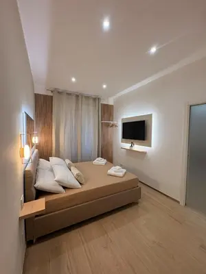 a bedroom with a large bed and a flat screen tv at Gianvenuti House Rome - Metro A with Jacuzzi in Rome